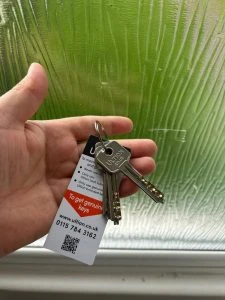 Hand holding Ultion house keys with branded key tag
