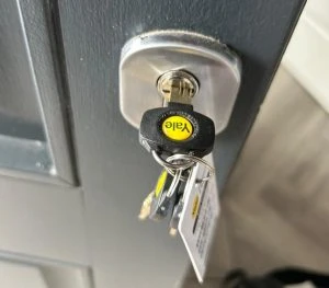 Yale key inserted in a door lock with keyring attached
