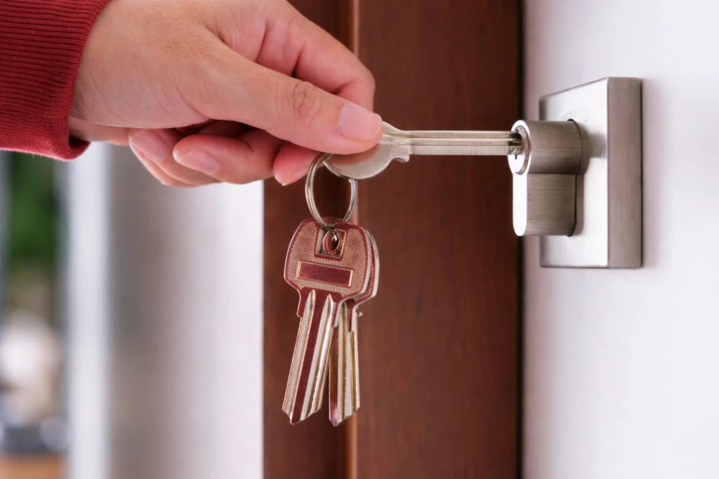 Hand inserting key into door lock for home security access